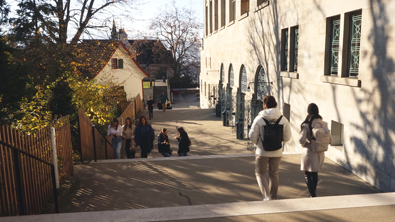 Students are walking downstairs next to the main building