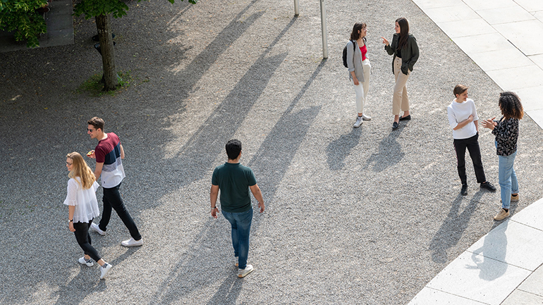 Blick von oben auf Studierende auf einem Platz